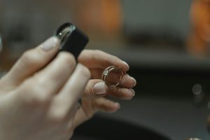 woman examining a gold ring, appraising its value